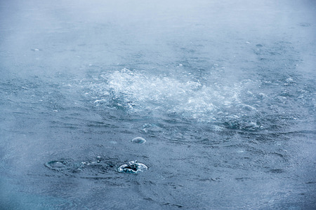 The bubbles of superheated colored blue waters of Crested Pool in Yellowstone, U.S.A.の写真素材