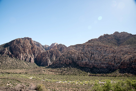 A massive rock wall with reflective image of the sun as a background.の写真素材