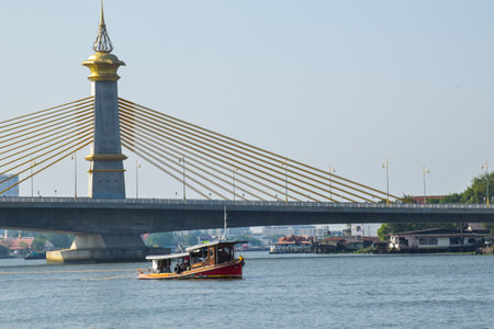Evening view of river suspension bridge and boats in Bangkok, Thailandの写真素材