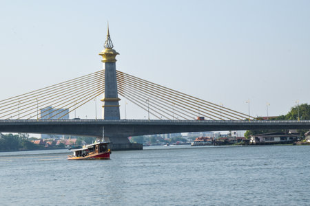 Evening view of river suspension bridge and boats in Bangkok, Thailandの写真素材