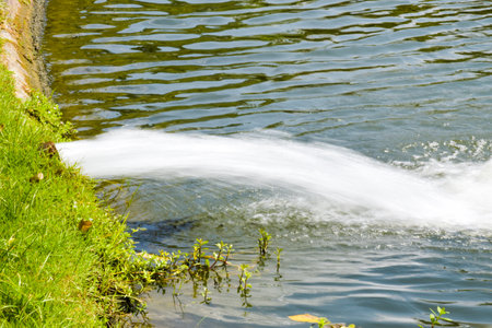 Waterfall in a park, close up of water flowing into the lakeの写真素材