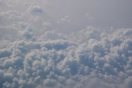 Sky and fluffy clouds above the sky from the plane window.