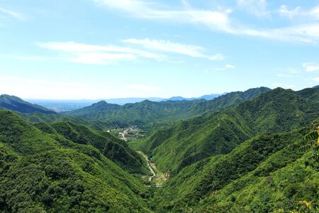 mountain landscape, with mountain peaks with forest and a cloudy skyの写真素材
