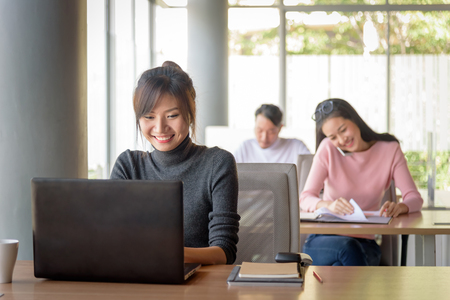 young beautiful asian smiling businesswoman working in startup office, happy work conceptの写真素材