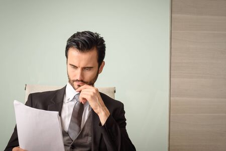 caucasian professional businessman reading financial report at office, copyspaceの写真素材
