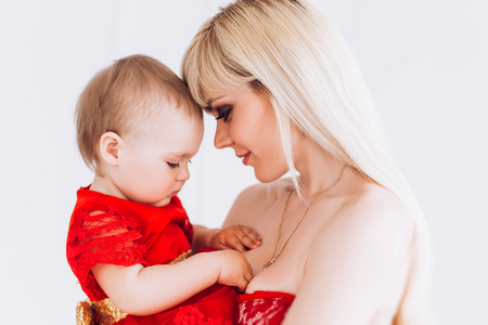 Nice, family, good photo of mother and daughter in red dresses in the studio. Mothers Day and daughters.の写真素材