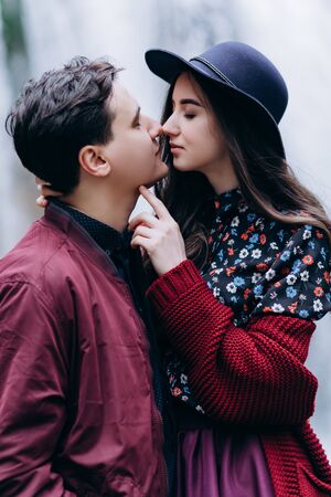 A loving, stylish, young couple in love on the background of a waterfall.