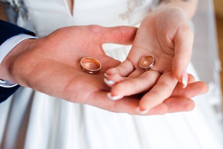 Wedding rings in the hands of the bride and groom.
