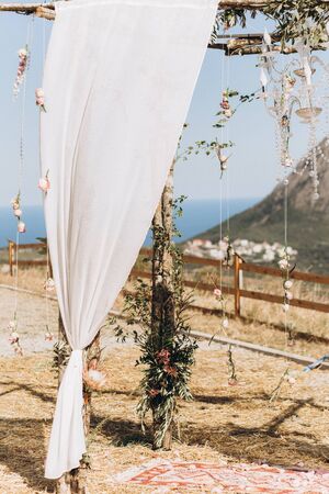 Arch decorated with lively floristics on the background of the sea and mountains.の写真素材