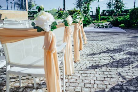 White wedding chairs with flowers on weddindの写真素材