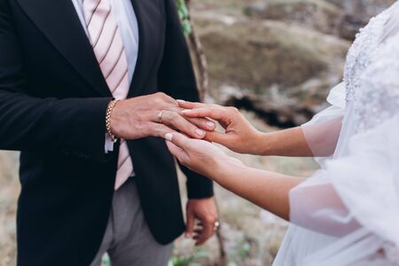 Wedding rings in the hands of the bride and groom.