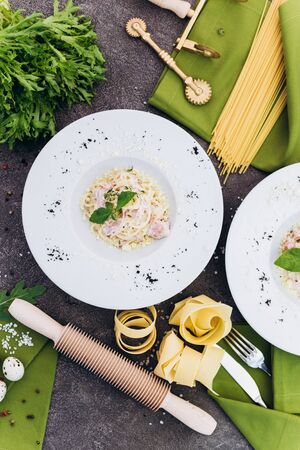 Spaghetti with olive color embellished with greenery, rolling pin, pasta.の写真素材