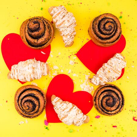 Delicate croissants with nuts and almonds on a yellow background.の写真素材
