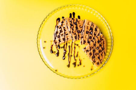 Waffles with chocolate on a yellow background.-Imageの写真素材