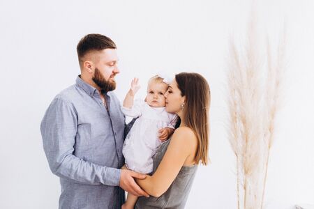 Happy young family in a bright studio. Full family.の写真素材