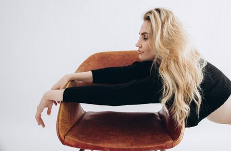 Portrait of a beautiful blonde girl with dark eyes in a black sweater.の写真素材