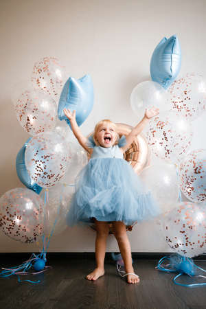 Birthday of a little blonde girl. Child in festive balloons.の写真素材
