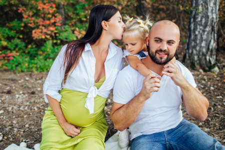 Happy family on a walk in the autumn forest.