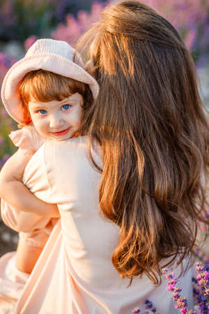 Charming girl in her mothers arms.の写真素材