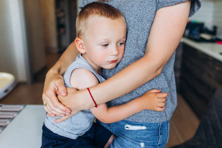 Mom hugs her son in the kitchen. Family in the kitchen.の写真素材