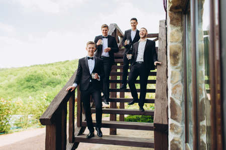 The groom and his friends celebrate the wedding. Men in suits. Mens emotions and friendship.の写真素材