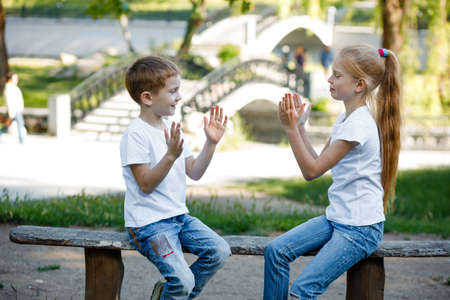 Cheerful children are playing in the park on a green bench.の写真素材