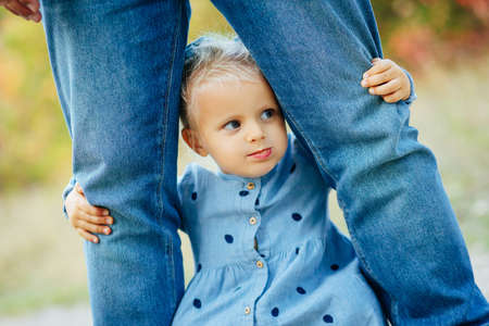Little white girl in a white blue dress laughs in forest. Preschooler.の写真素材