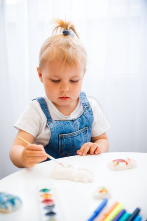 Little girl learns to paint with paints.の写真素材