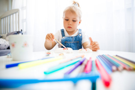 Little girl learns to paint with paints.の写真素材