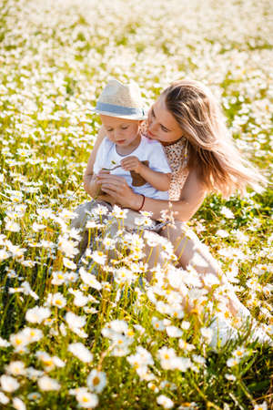 Mother and son are playing in a green meadow.の写真素材