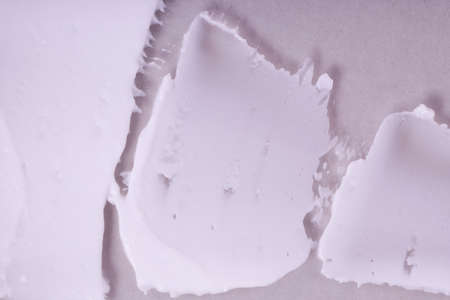 Smeared textured cream on a gray background. Macro shot of a creamy texture.の写真素材