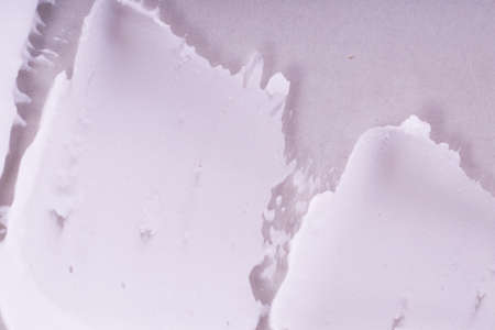Smeared textured cream on a gray background. Macro shot of a creamy texture.の写真素材