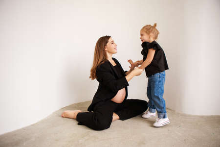 Mother and daughter in black outfits hug each other. Mothers Day.の写真素材