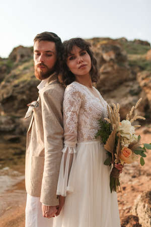 Boho bouquet of roses in the hands of the bride. Weddind couple boho style.の写真素材