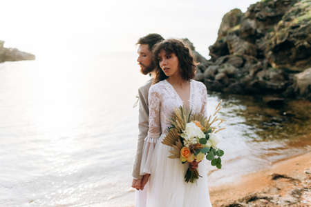 Wedding on the sunset with live floristry. Bride and groom in boho style.の写真素材