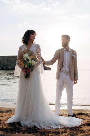 Wedding on the sunset with live floristry. Bride and groom in boho style.の写真素材