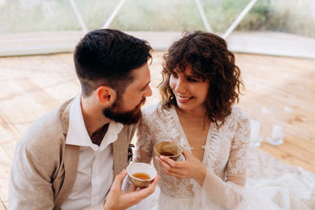Tea ceremony at a boho wedding. Bride and groom in boho.の写真素材