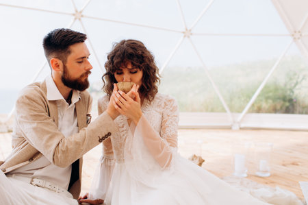 Tea ceremony at a boho wedding. Bride and groom in boho.の写真素材