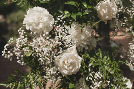 Wedding arch on boho style with white flowers in park.の写真素材