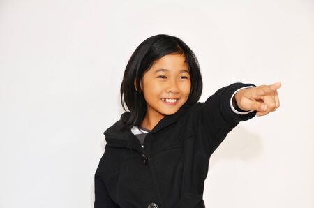 A happy cutie girl is pointing her finger at somethingの写真素材