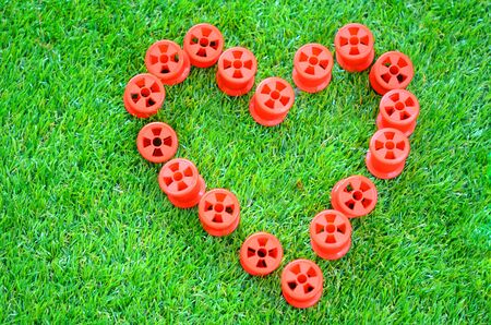 A spool love heart on green grass backgroundの写真素材