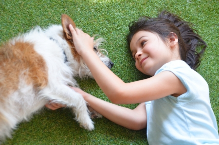 A cutie girl plays with a dog; Jack Russel teriorの写真素材