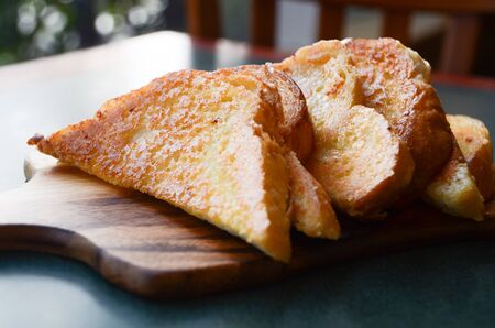 Cheesy garlic bread on a cutting board