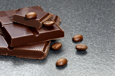Dark chocolate and coffee beans on a stone tableの写真素材