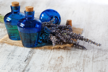 Lavender oil in a glass bottle on a wooden tableの写真素材