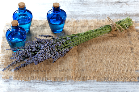 Lavender oil in a glass bottle on a wooden tableの写真素材