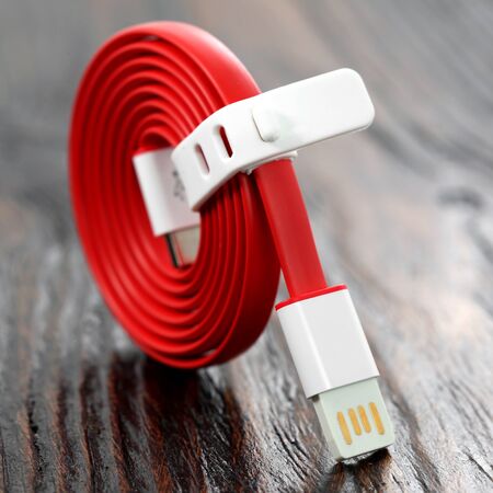 Red USB cable on wooden table