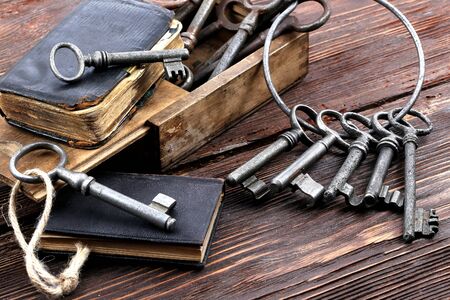 Old metal keys and a vintage book on a wooden tableの写真素材
