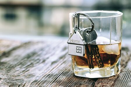 Keychain figure of house with keys and alcoholic drinkの写真素材