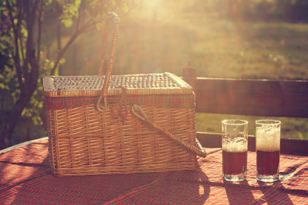 Picnic basket on the table at sunsetの写真素材